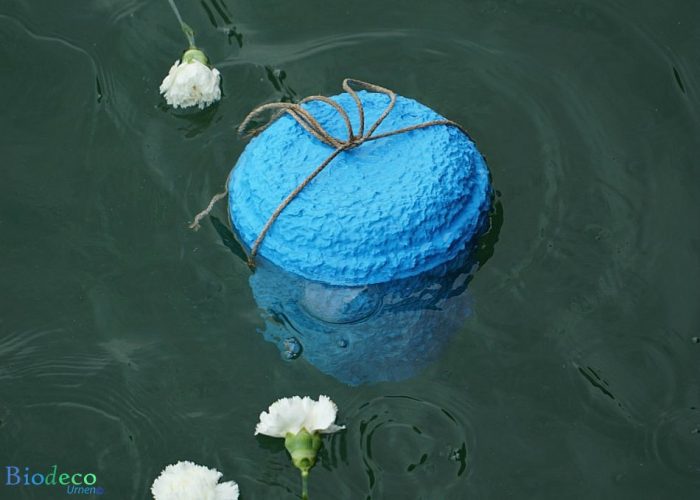 De zee-urn Zeeblauw, bijgezet in de Noordzee voor de kust van Hoek van Holland, met bloemen als laatste groet