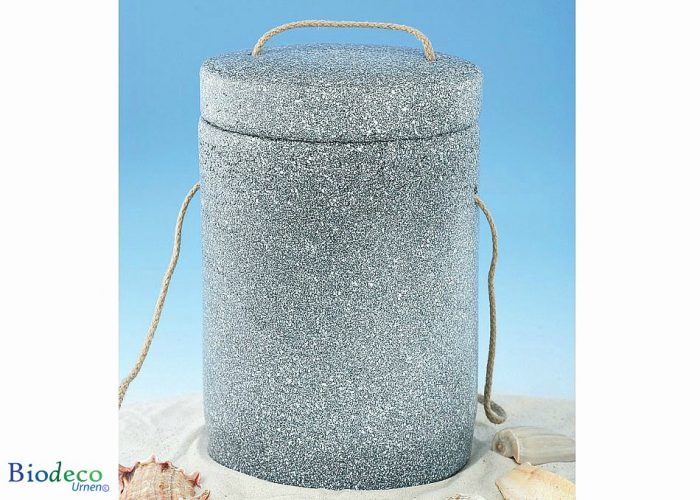 De biologisch afbreekbare zee-urn Basaltlava in het zand, met touw voor een asbijzetting in het water
